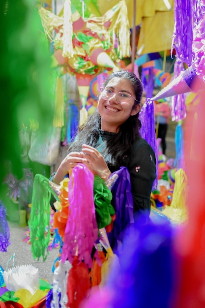 Foto mujer latina de navidad mexicana rompiendo una piata y celebrando una posada tradicional en méxico