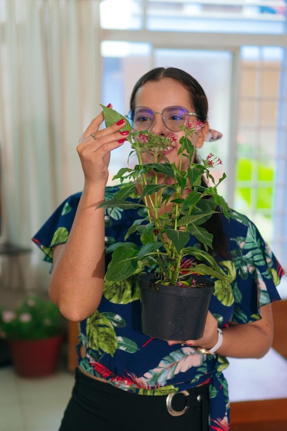 Mujer latina organizando la decoración del interior de la casa. Jungla urbana