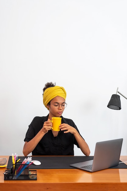 Mujer latina que trabaja en la oficina en casa con ordenador portátil y documentos