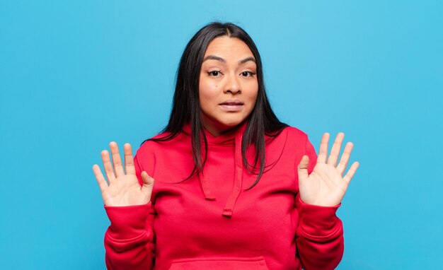 Mujer latina que se ve nerviosa, ansiosa y preocupada, diciendo que no es mi culpa