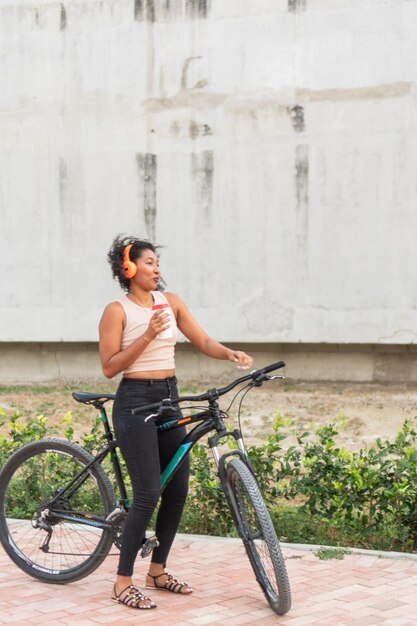 Foto mujer latina riendo con café mientras descansa en bicicleta