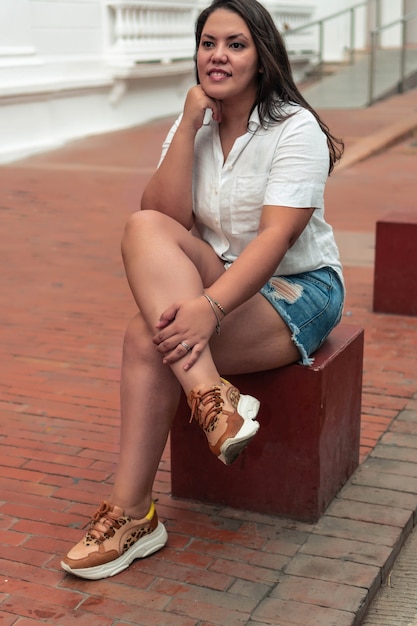 Mujer latina sentada en la calle por la tarde