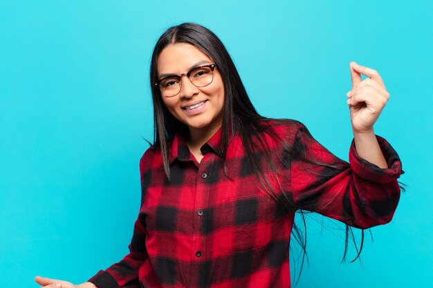 Foto mujer latina sonriendo, sintiéndose despreocupada, relajada y feliz, bailando y escuchando música, divirtiéndose en una fiesta