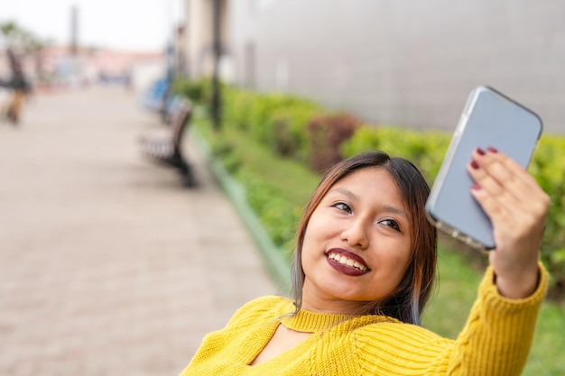 Mujer latina tomando selfie en la calle