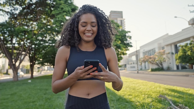 Mujer latina usando smartphone en el parque. Chica brasileña.