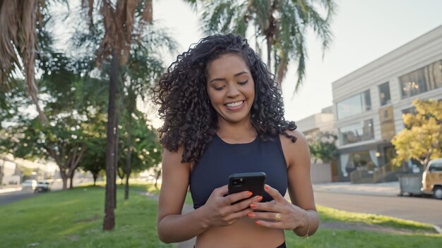 Mujer latina usando smartphone en el parque. Chica brasileña.