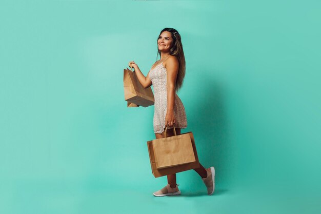 Foto mujer latinoamericana latinx camina sonriendo mientras sostiene bolsas de papel de compras concepto de viernes negro