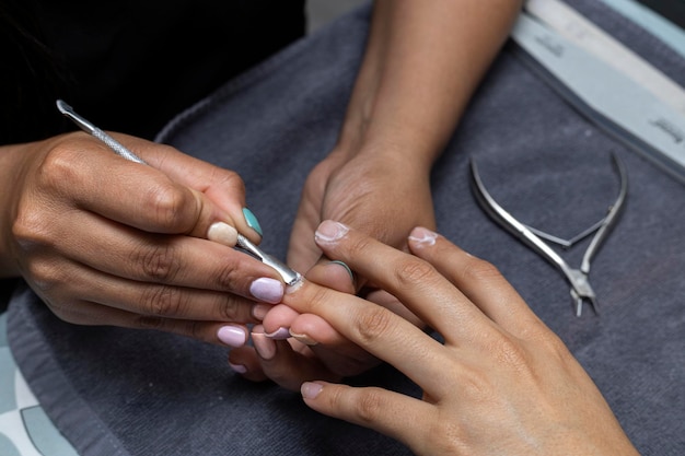 Una mujer latinoamericana recibe un tratamiento de manicura en un salón de belleza