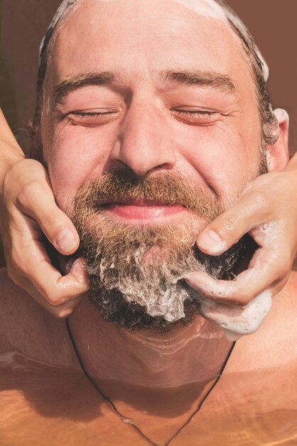 Foto mujer lava una barba de hombre en el río