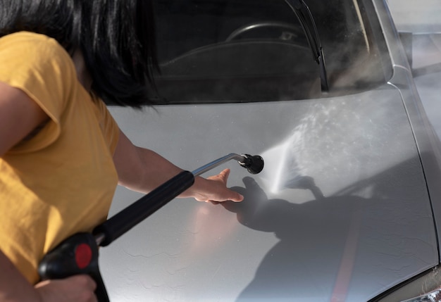 Mujer lavando el coche en un túnel de lavado