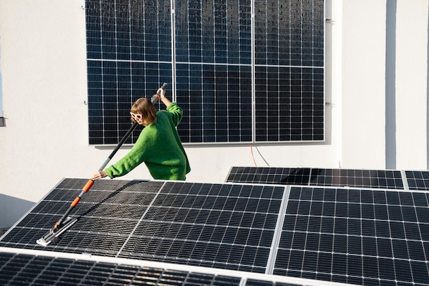 Mujer lavando paneles solares en la azotea