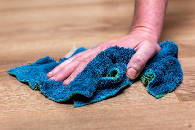 Mujer lavando el piso con un trapo azul