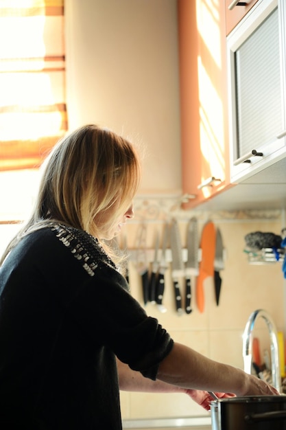 Mujer lavando platos en la cocina