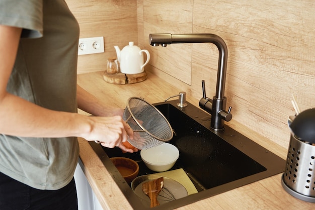 Foto mujer lavando platos en el fregadero de la cocina