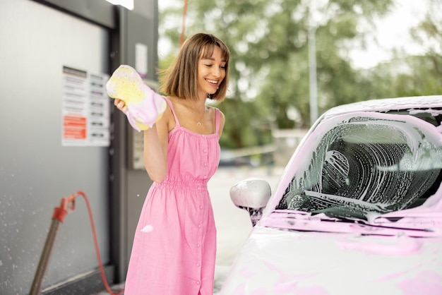 Mujer lavando su auto en un autolavado de autos