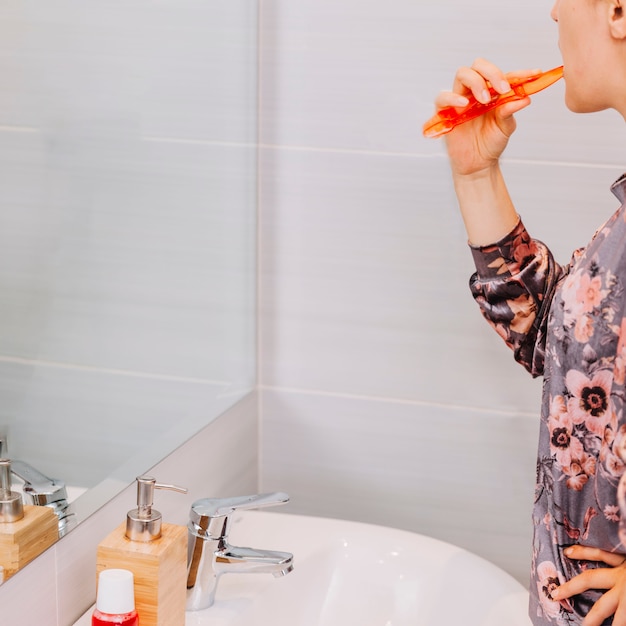 Foto mujer lavándose los dientes