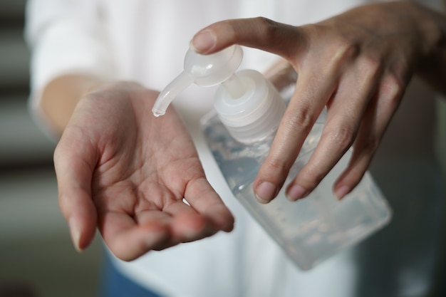 Mujer lavándose las manos con gel de alcohol o gel desinfectante, contra virus