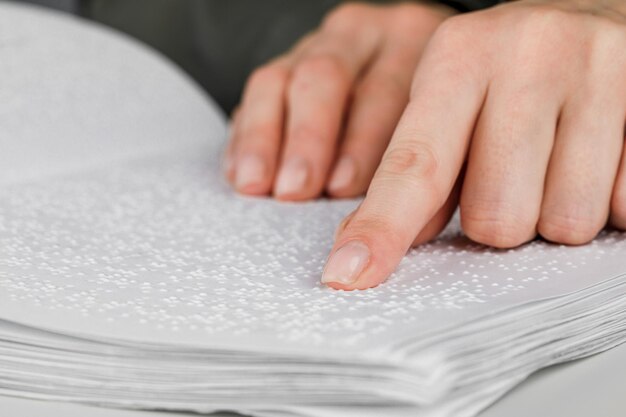 Una mujer lee un libro escrito en Braille.