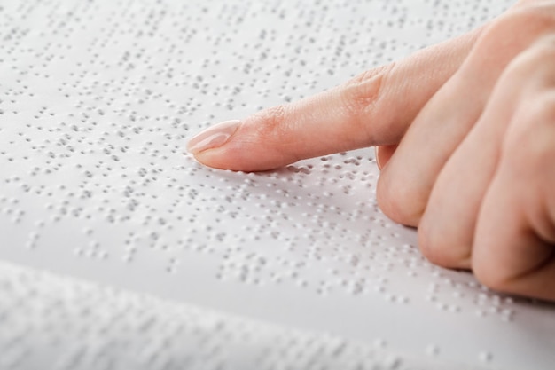 Una mujer lee un libro escrito en Braille