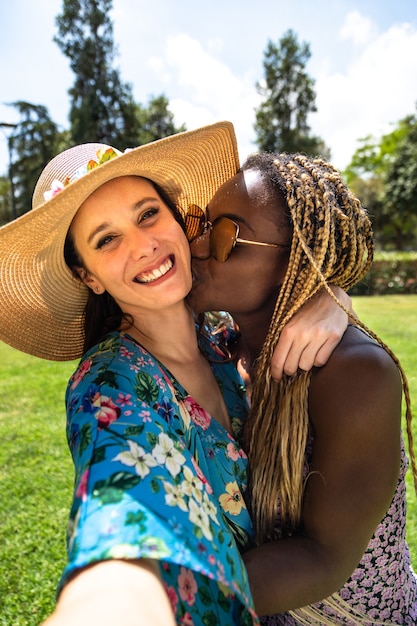 Mujer lesbiana afroamericana beso a novia en la mejilla Pareja gay tomar selfie vacaciones LGBT