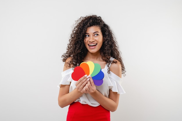 Mujer lesbiana negra sosteniendo corazones con colores de la bandera lgbt aislados