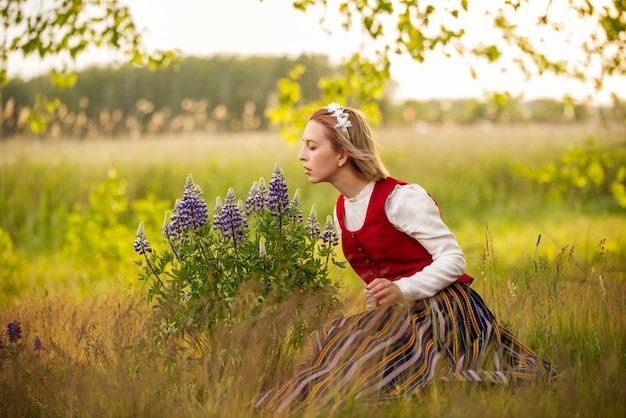 Mujer letona en vestimentas tradicionales en campo