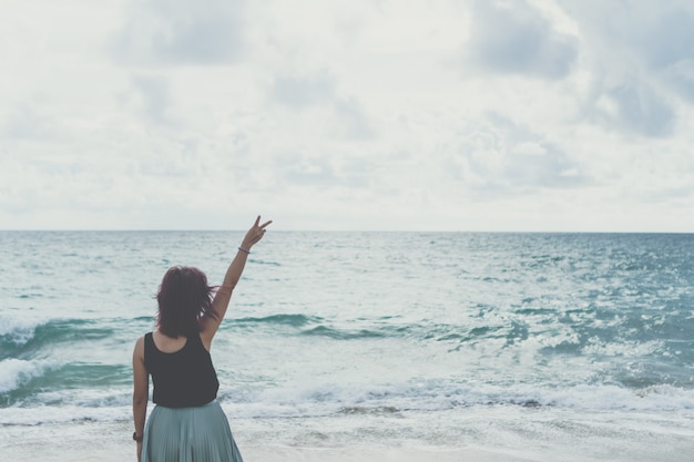 Mujer levanta las manos hasta el cielo