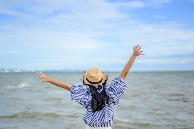 Mujer levanta su mano en la playa.