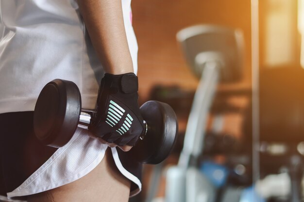 Foto mujer levantando pesas en el gimnasio