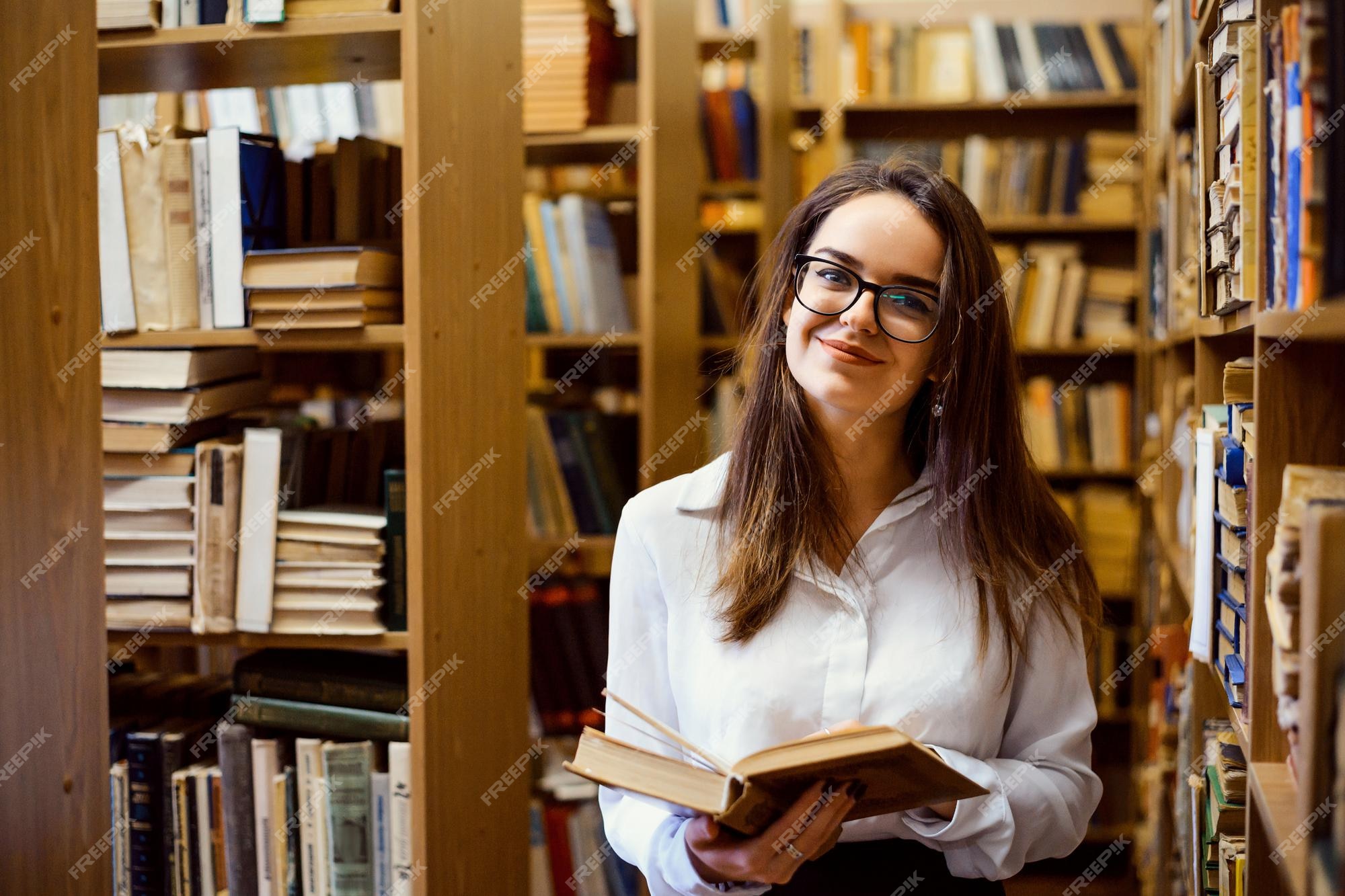 Mujer leyendo un libro en la biblioteca | Foto Premium