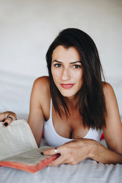 Mujer leyendo un libro en la cama