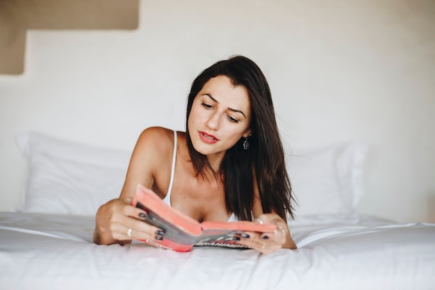 Mujer leyendo un libro en la cama