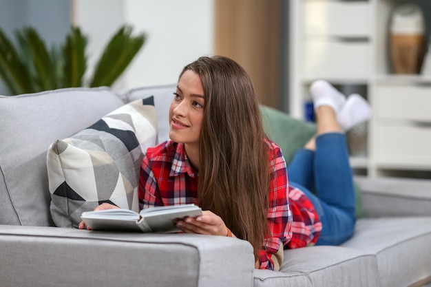 Mujer leyendo un libro en casa