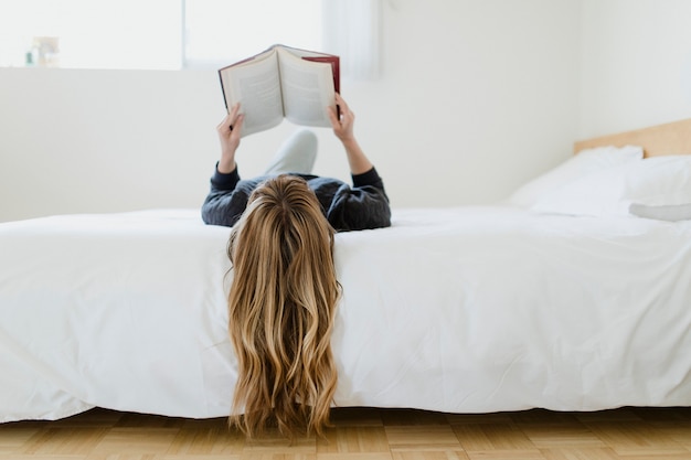 Mujer leyendo un libro en casa