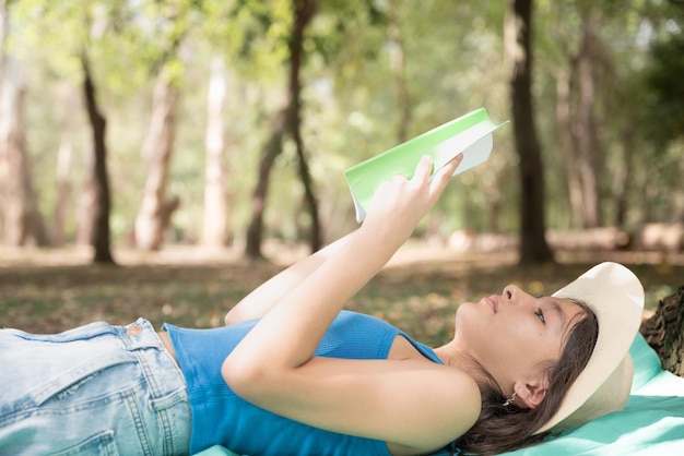 Foto mujer leyendo libro y descansando en el bosque