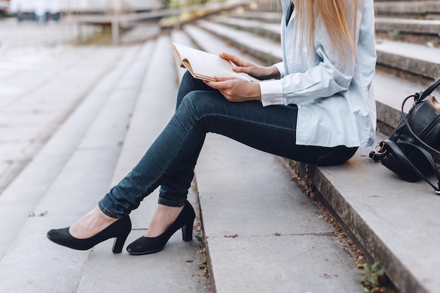 Mujer leyendo libro en las escaleras