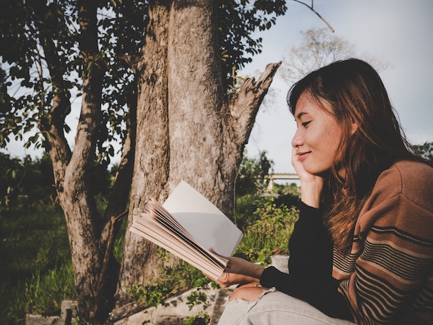 la mujer leyendo el libro en la naturaleza.