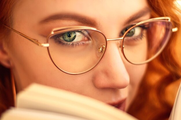 Foto una mujer leyendo un libro con un ojo verde.