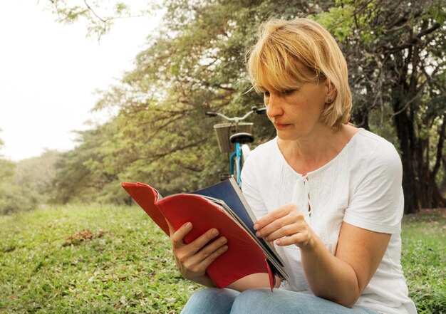 Foto mujer leyendo un libro en el parque