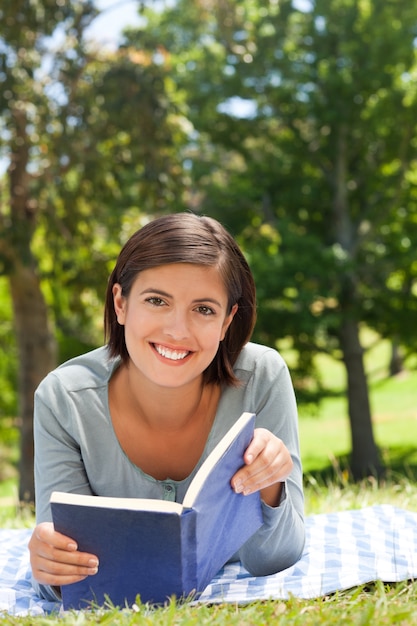 Mujer leyendo un libro en el parque