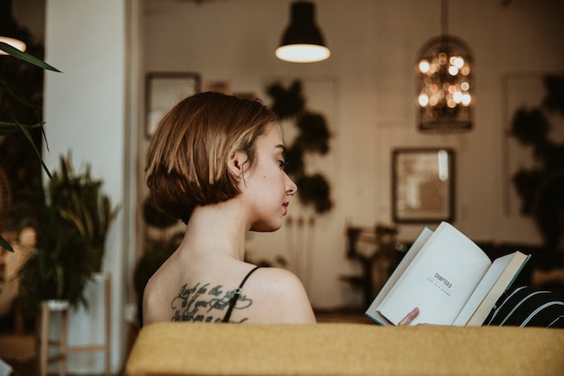 Mujer leyendo un libro en su sala de estar