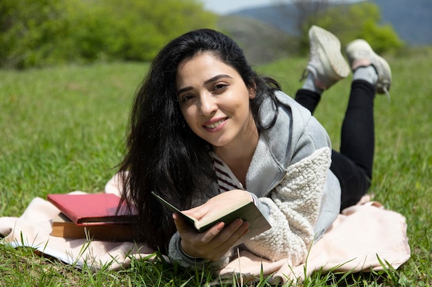 Mujer leyendo libros en la naturaleza