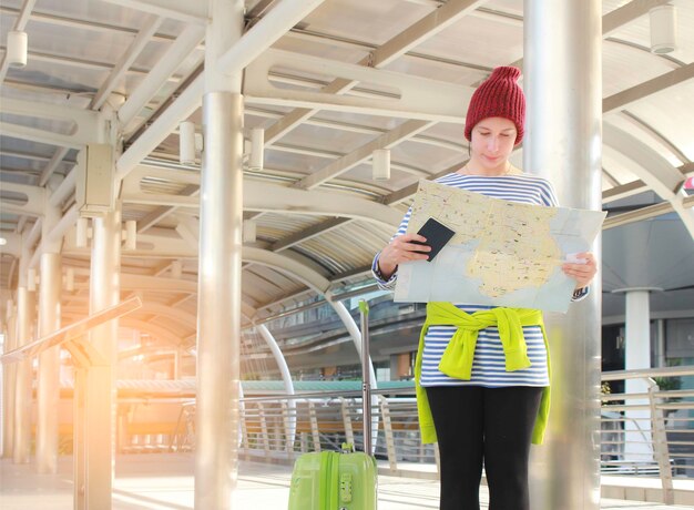 Foto mujer leyendo un mapa mientras está de pie al aire libre