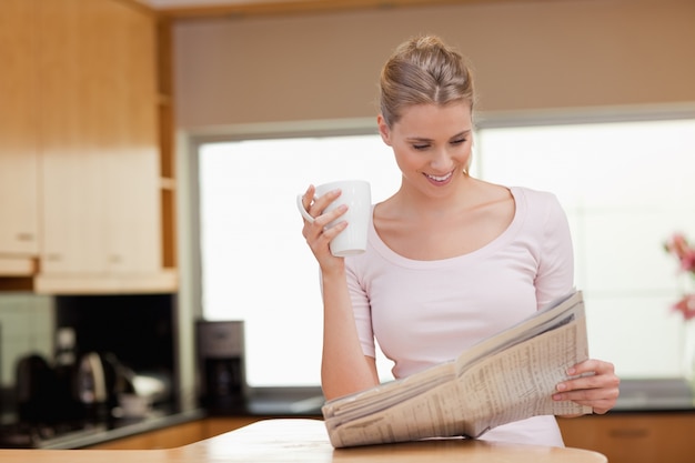 Mujer leyendo las noticias mientras toma el té