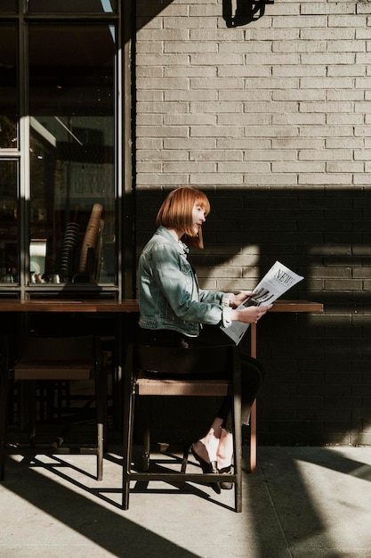 Mujer leyendo un periódico en un café