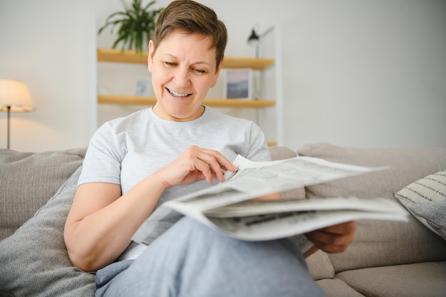 Mujer leyendo el periódico en casa