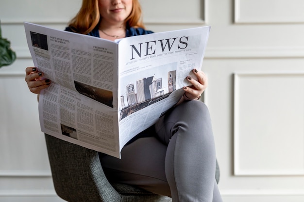 Mujer leyendo el periódico en casa