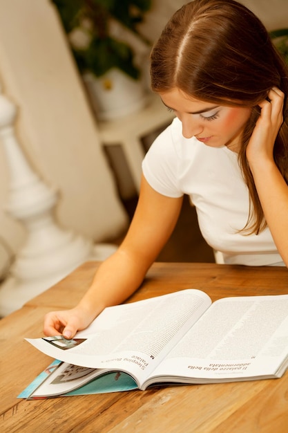 Mujer leyendo una revista a la hora del té