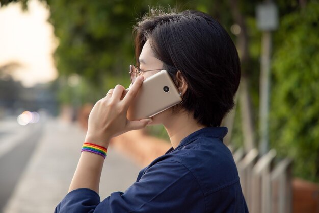 Mujer LGBT moderna con símbolo de cinta usando el concepto de teléfono inteligente de personas LGBT o LGBTQ comunidad amigos socio campaña de derechos lgbt igualdad matrimonio del mismo sexo preferencia sexual diversidad