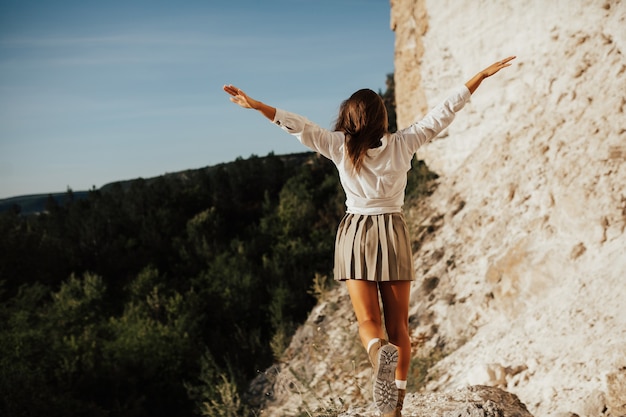 Mujer libre feliz despreocupada disfrutando de la naturaleza en la montaña